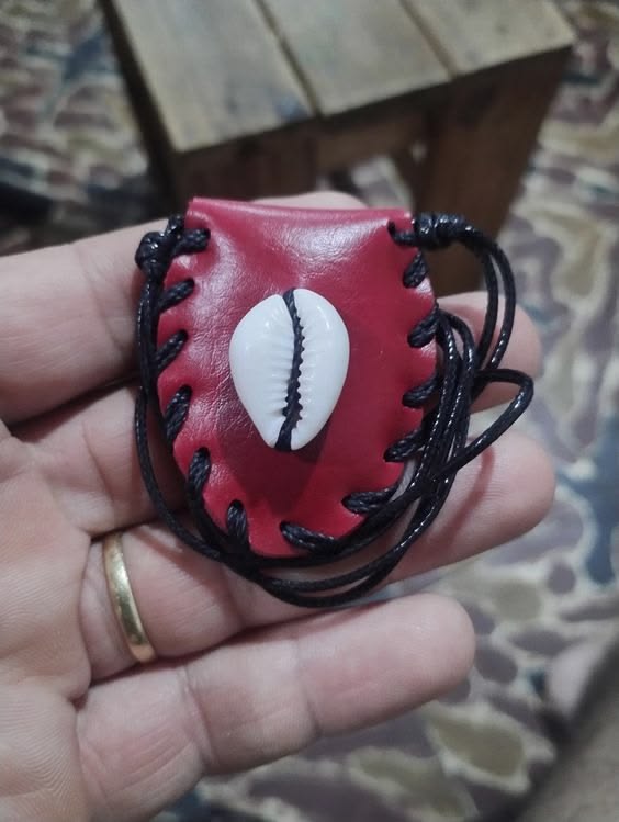 Red leather attraction charm decorated with a cowrie shell