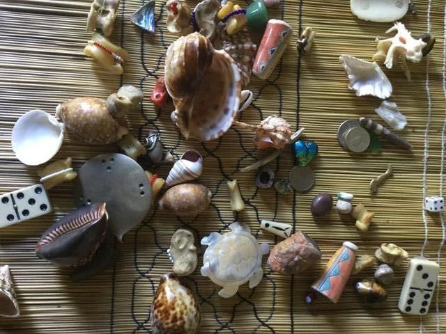 Divination bones and shells laid out on a woven mat