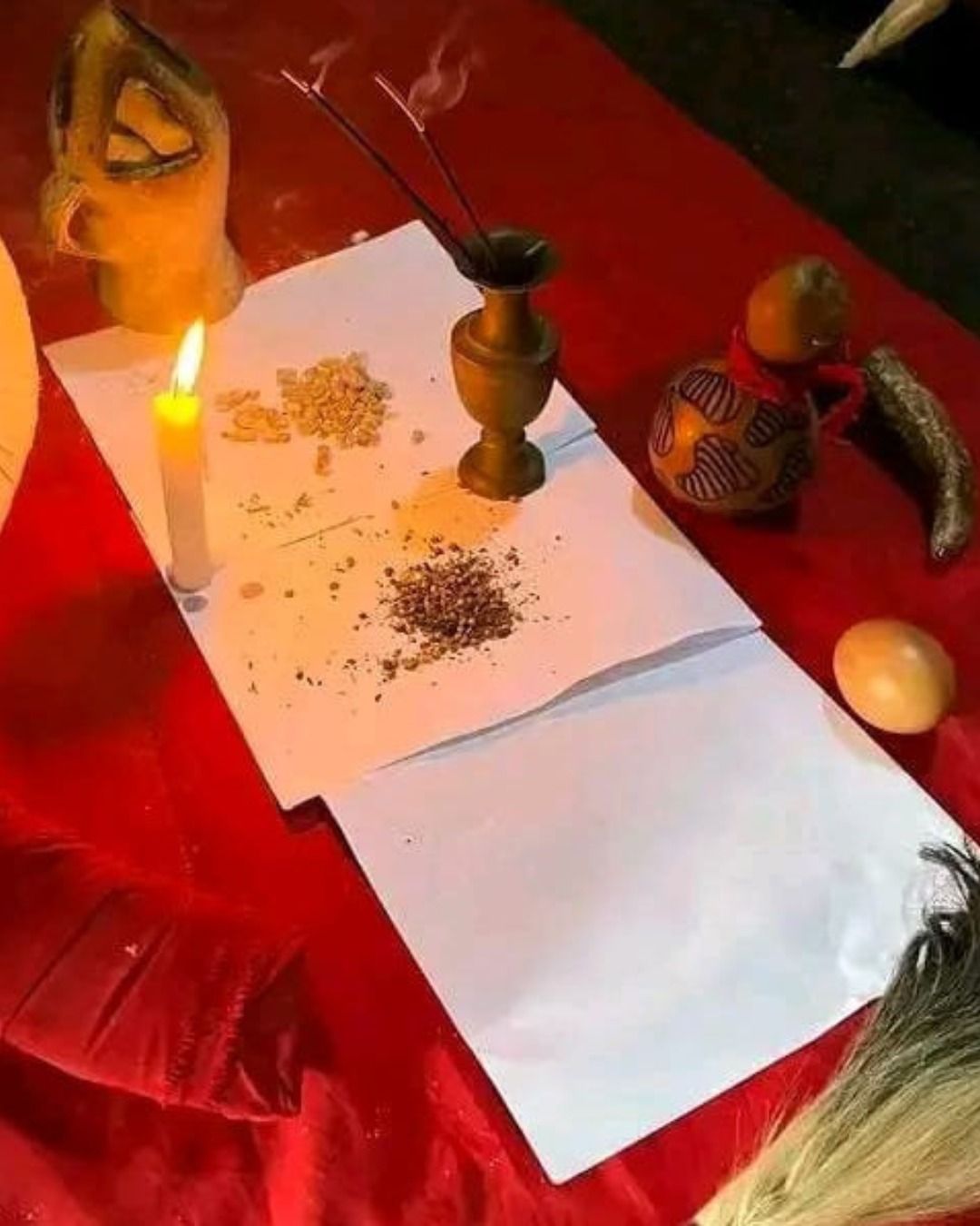 Herbs, incense and a candle laid out for a traditional herbal ritual