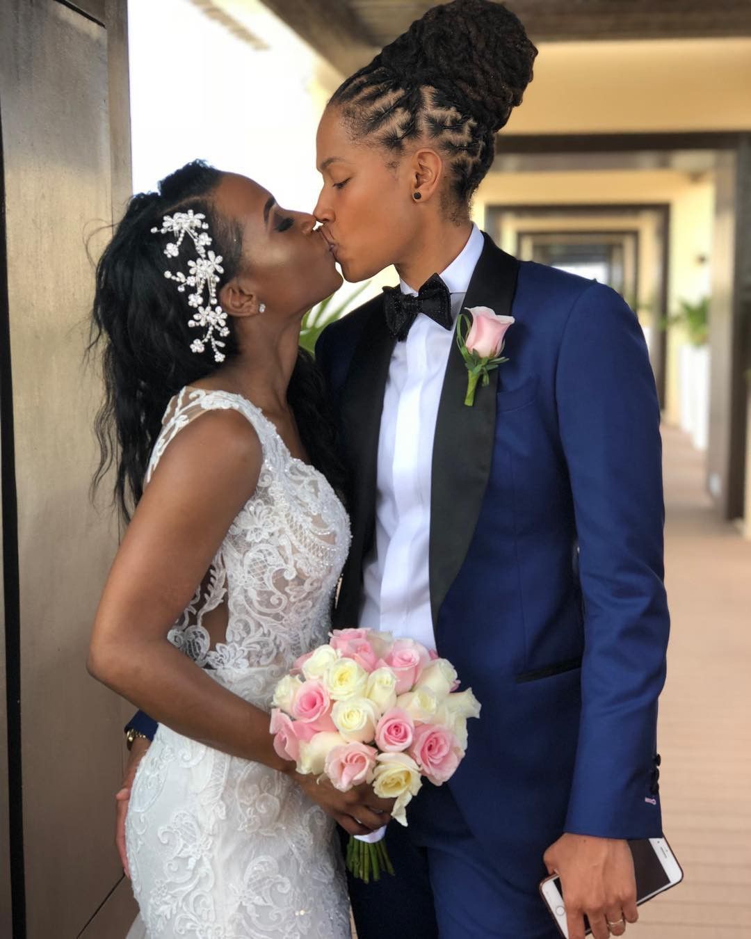 Two brides kissing on their wedding day