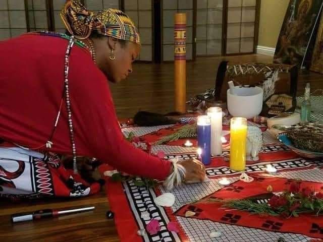 Traditional healer preparing an altar with candles